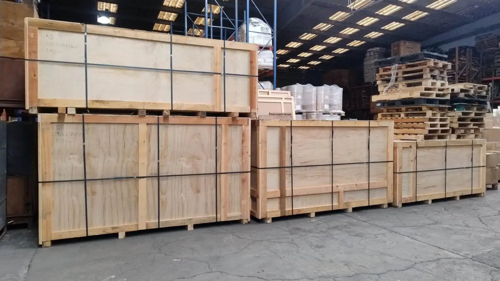 Reinforced and certified wooden export crates stored in an industrial warehouse.