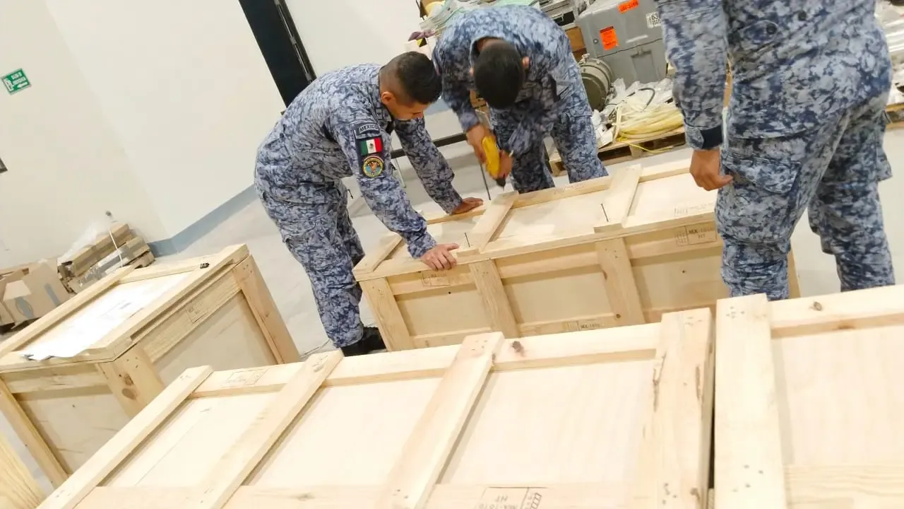 Personal operativo trabajando en el embalaje y preparación de cajas de madera para distribución nacional.