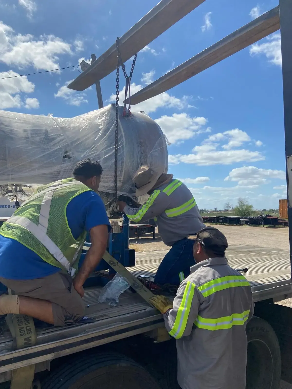 Technical staff overseeing the transport of a large-scale aircraft engine on a specialized platform.