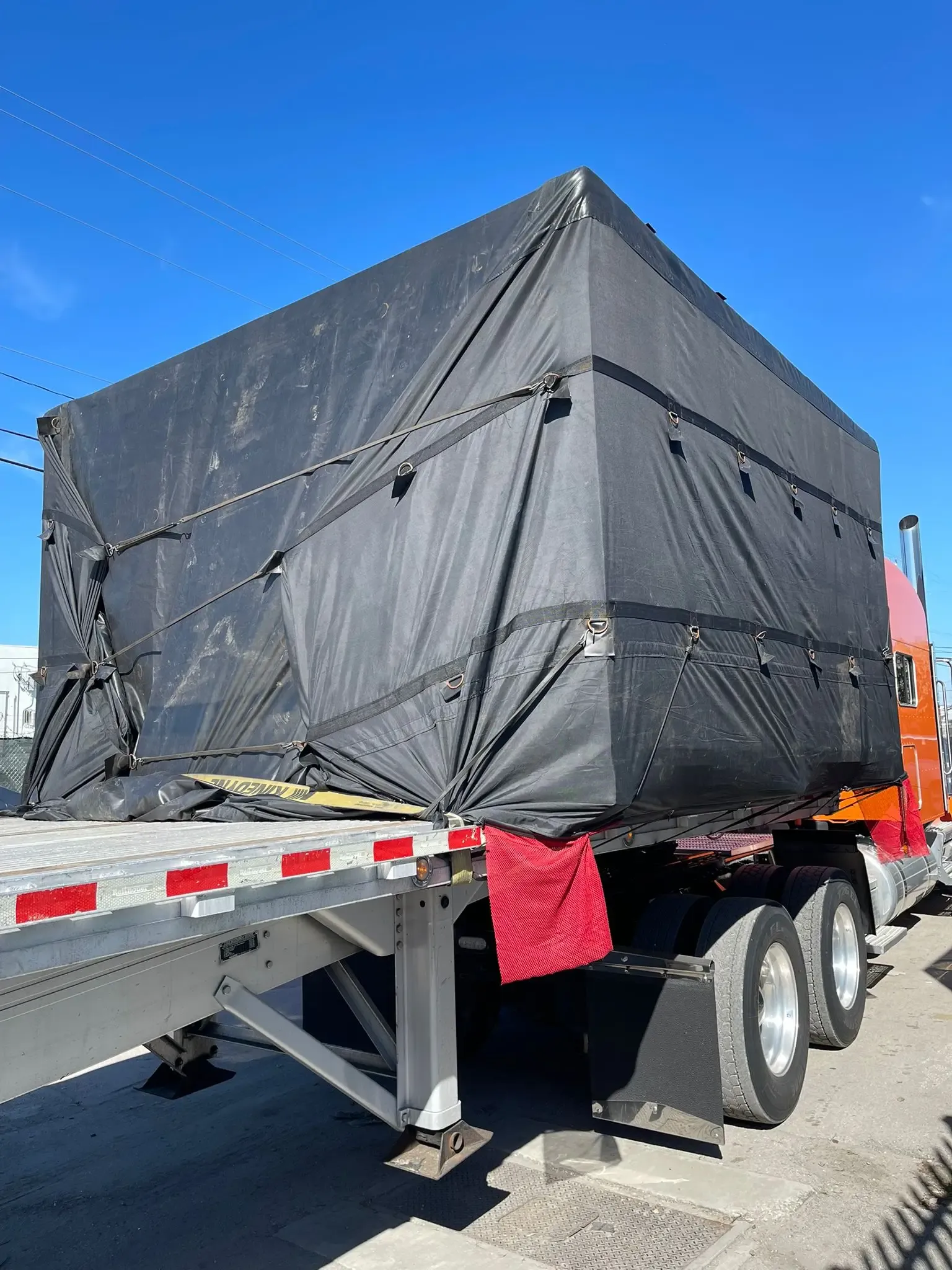 Land transport of Mitsubishi Power containers and equipment on a specialized flatbed.