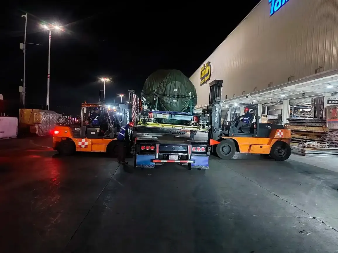 Lifting maneuver of a turbofan engine using heavy-duty loading equipment in a hangar.