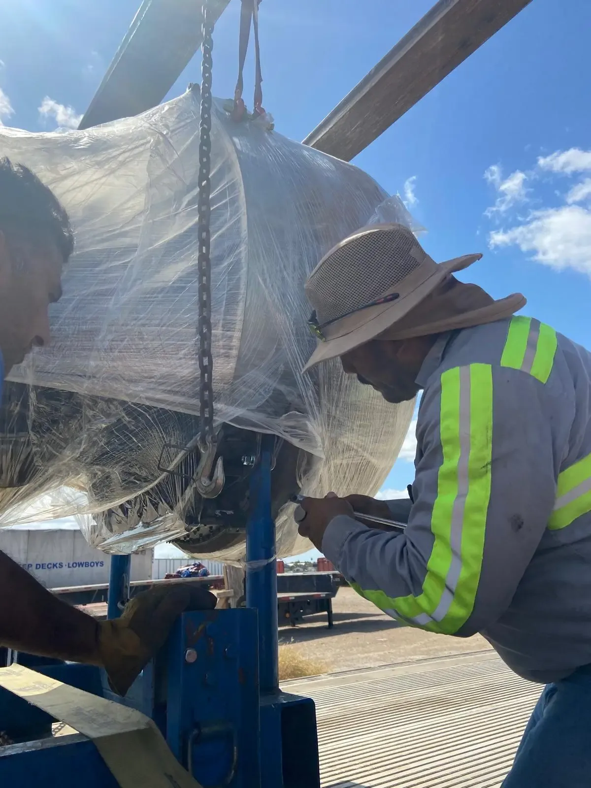 Técnico especializado realizando ajustes en la estructura de un motor de aviación durante su preparación logística.