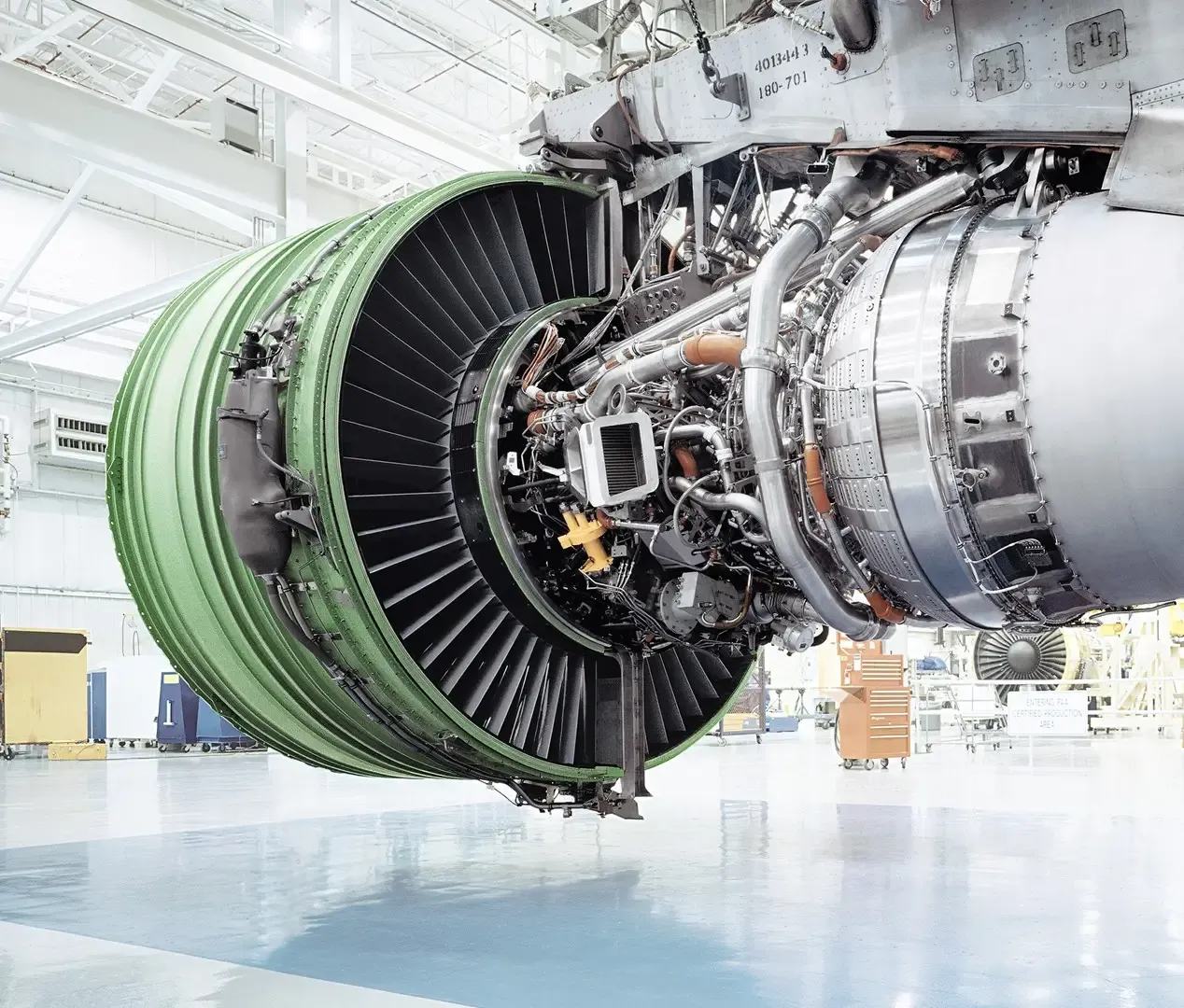 Motor GE Aviation de gran tamaño montado en soporte de transporte en hangar.