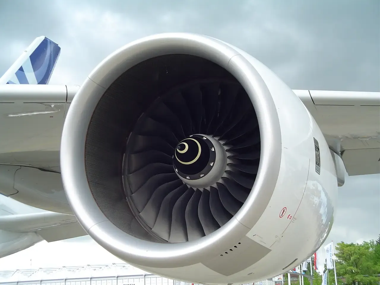 Front view of the fan of a Rolls-Royce Trent series engine on a runway.