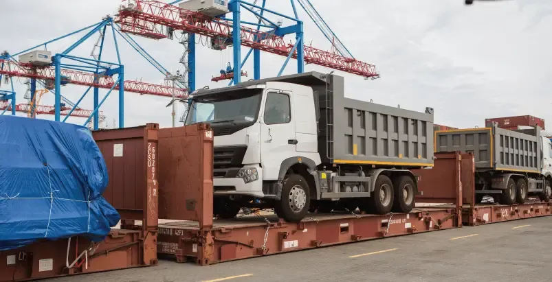 Camión transportando un contenedor en plataforma para el servicio de carga sobredimensionada.