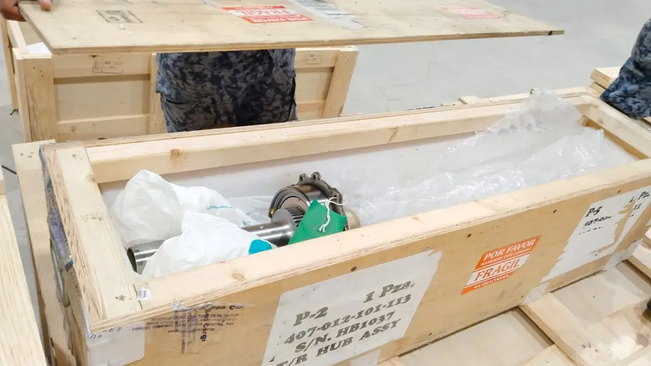 Personal técnico especializado fabricando huacales de madera reforzados para maquinaria pesada.