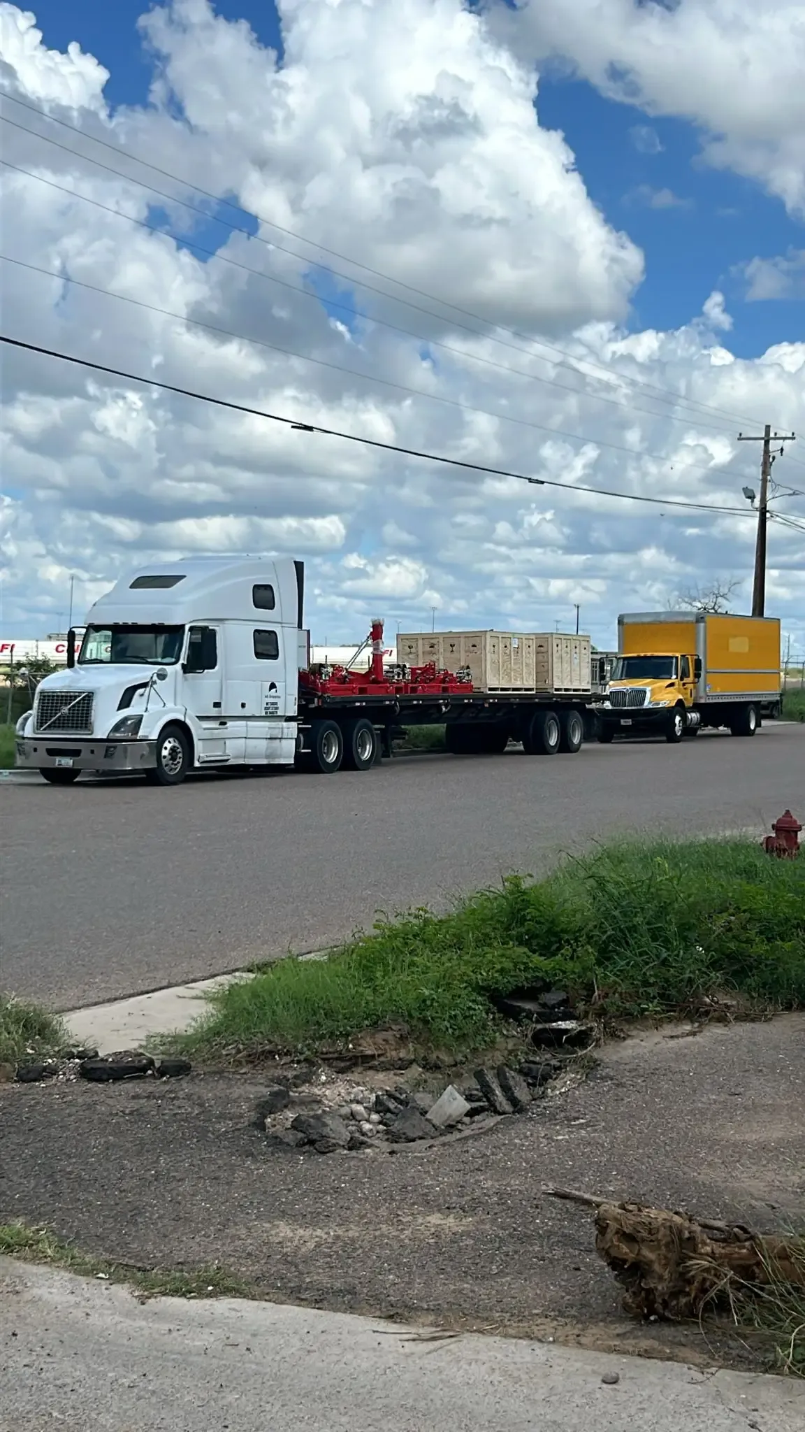 Flatbed trailer transporting reinforced wooden crates for industrial cargo on the highway.
